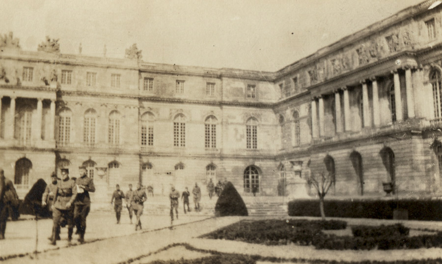 Sepia photo of a French palace courtyard filed with WWI-era soldiers
