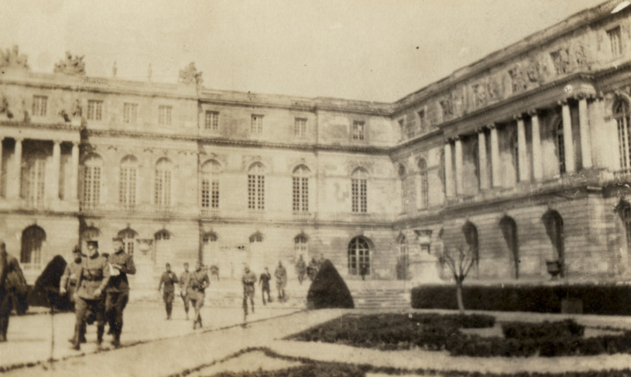 Photo sépia d'une cour de palais française remplie de soldats de la Première Guerre mondiale