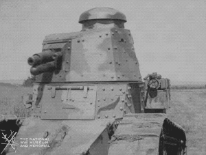 Animated gif of black and white film footage. A small tank in an empty field. The turret rotates and multiple hatches open from the inside revealing several soldiers.