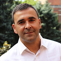 Headshot of a medium-tan man with short brown hair