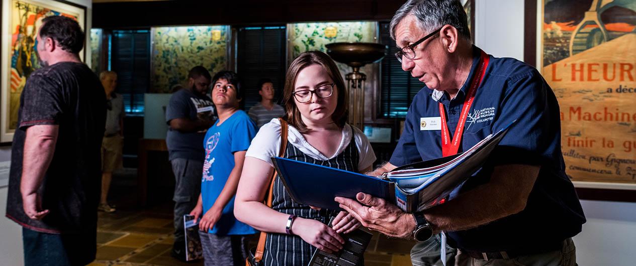 Volunteer assisting woman in gallery