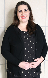 Three-quarters headshot of a smiling white woman with dark brown hair