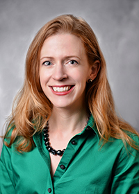 Headshot of a white woman with strawberry blonde hair
