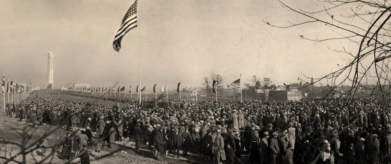 Sepia picture of a large crowd of people filling the mall in front of the Liberty Memorial.