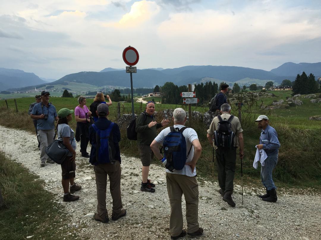 Man talking to the group in front of signpost