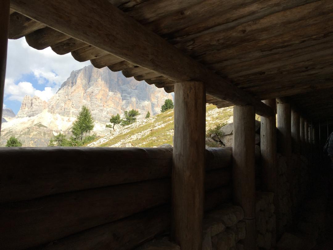 Looking out from a trench with a shed-like roof at a mountain landscape