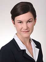 Headshot of a white woman with short dark brown hair wearing a black suit jacket