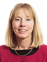 Headshot of a middle-aged white woman with blonde hair wearing a red shirt