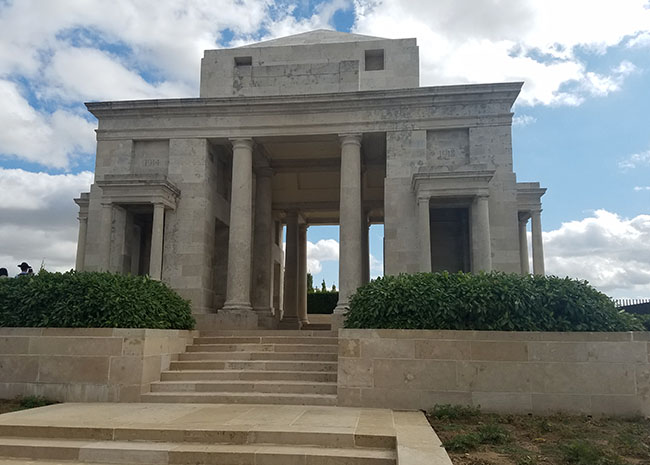 Photograph of a large open-air stone building supported by columns.