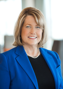 Headshot of a white woman with blonde hair wearing a blue suit jacket