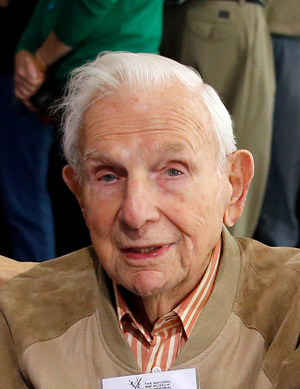 Photograph of an old white man wearing a tan jacket.