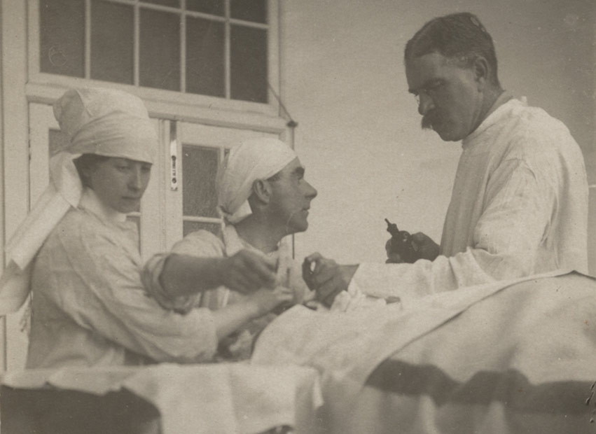 A nurse assisting doctor with an operation.