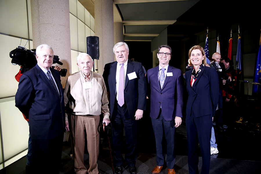 Modern photograph of a group of older white people in business casual attire, along with President and CEO Matt Naylor.