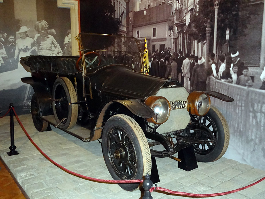 Museum display of an early 1900s open-air automobile