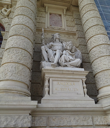 Statue between two columns depicting a male indigenous American and a female indigenous Australian and child