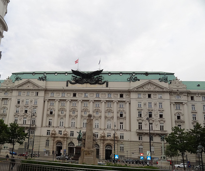 Front of a large early 1900s building with a green roof