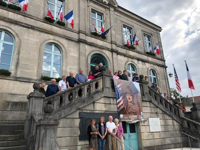 The tour group gathered on the steps in front of an old town hall building.