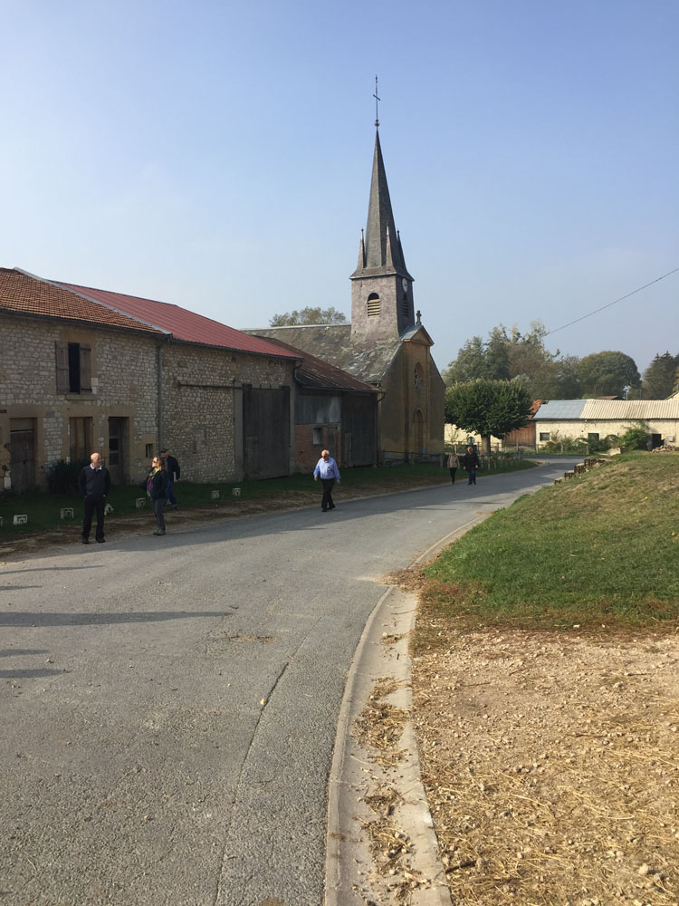 Tour group on a street beside a church with a spire