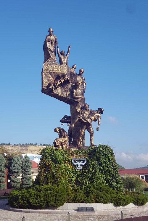 Large bronze sculpture depicting several figures from WWI