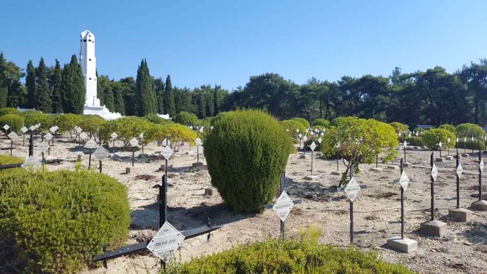 Rows of grave markers fenced in by barbed wire.