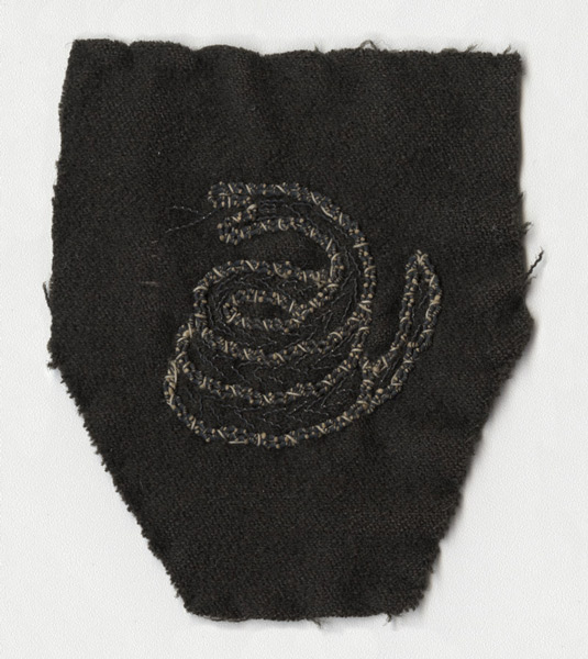 Photograph of a sleeve insignia depicting a coiled-up rattlesnake