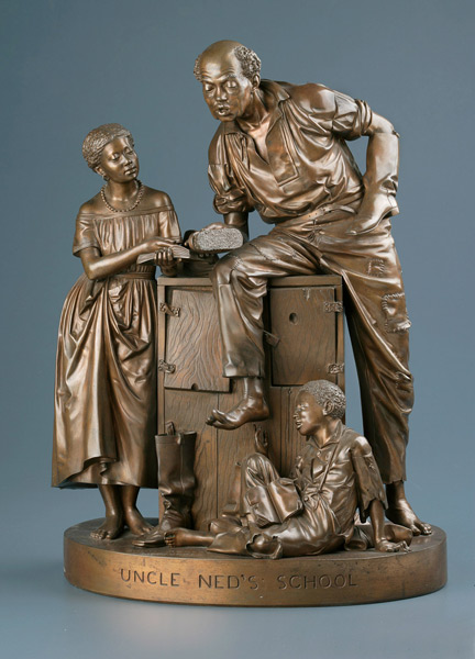 Photograph of a bronze statue depicting an adult Black man dressed in casual shirt and trousers leaning against a cabinet, speaking to a Black girl standing in a dress and a Black boy sitting on the ground.