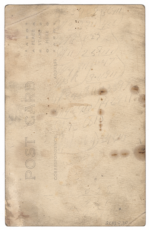 Scan of the faded back of a postcard with illegible cursive writing