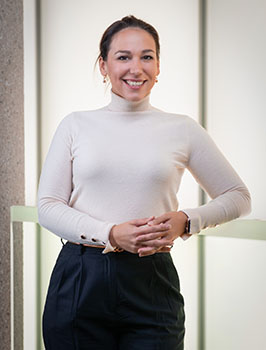 Headshot of a white woman wearing a cream turtleneck top