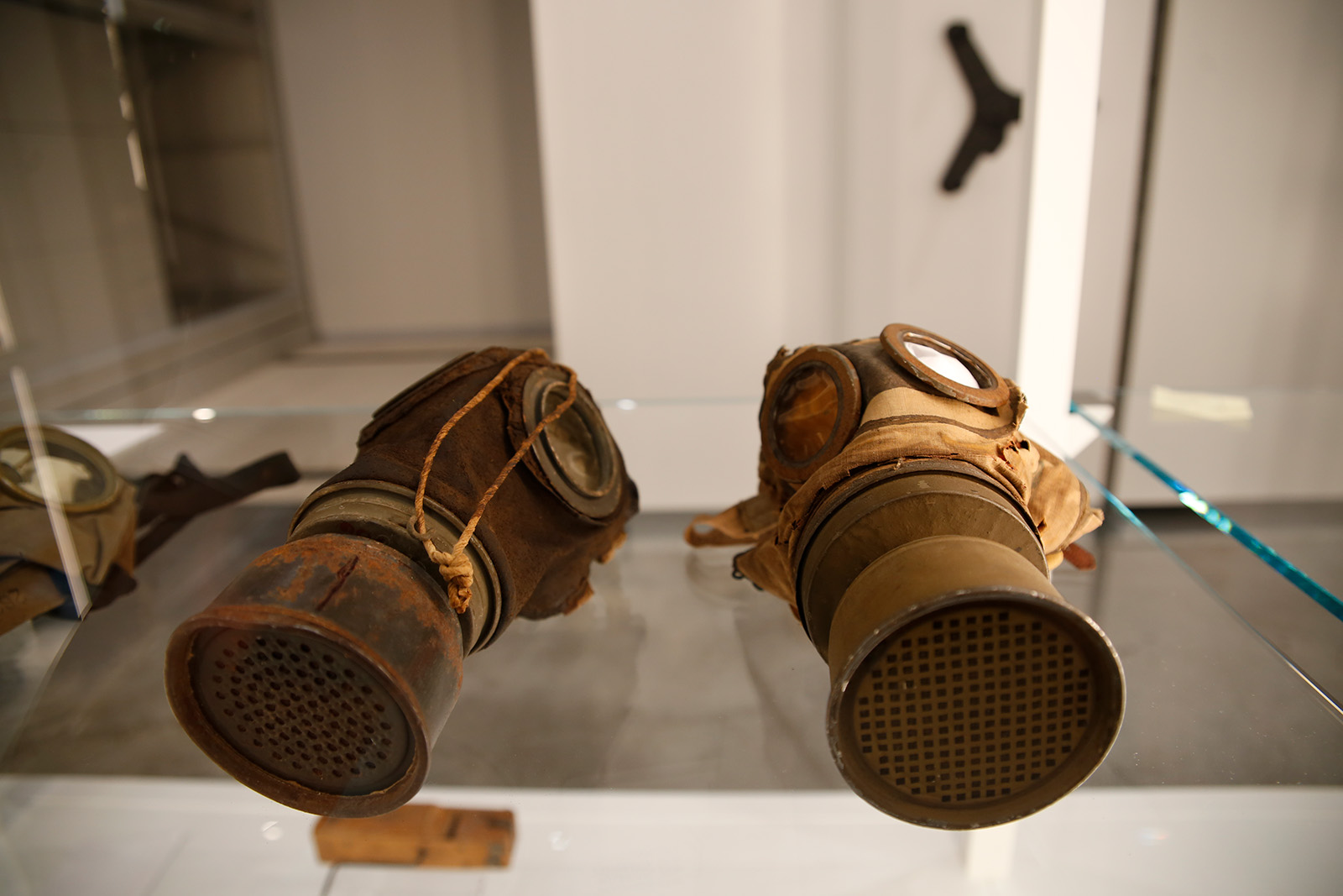 Modern photograph of a glass display case featuring two WWI-era gas masks