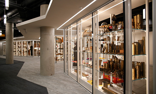 Modern photograph of glass shelving stretching away from the viewer, filled with WWI artifacts