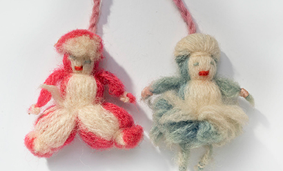 Modern photograph of small humanoid figures made of yarn.