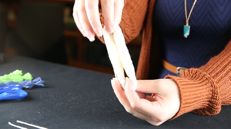 A person holding the bundle of looped yarn