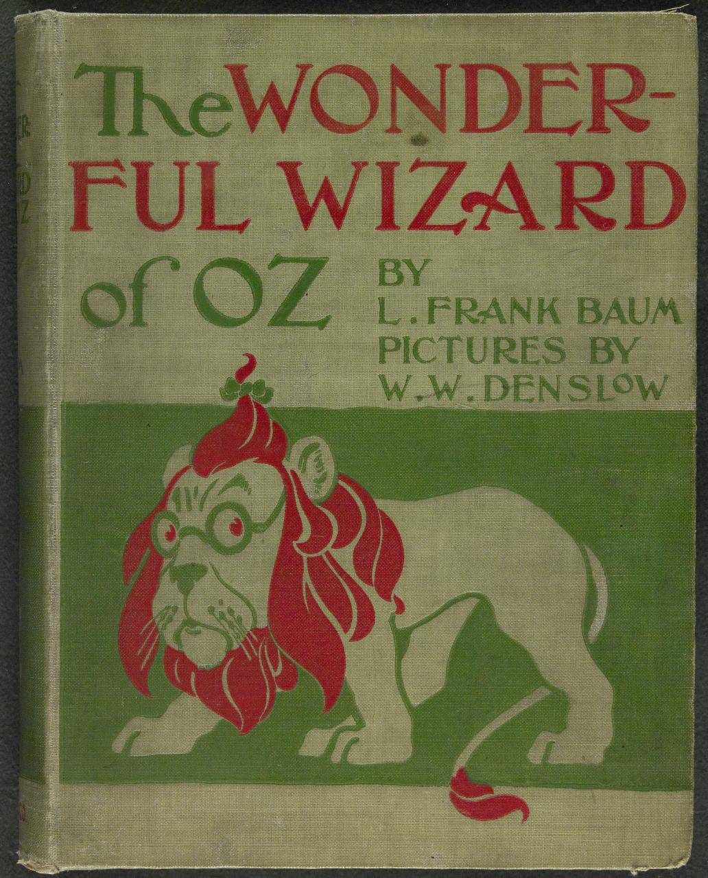 Old book cover in green and red. Illustrated with a cartoon lion looking around with scared eyes. Text: 'The Wonderful Wizard of Oz / by L. Frank Baum / Pictures by W. W. Denslow'