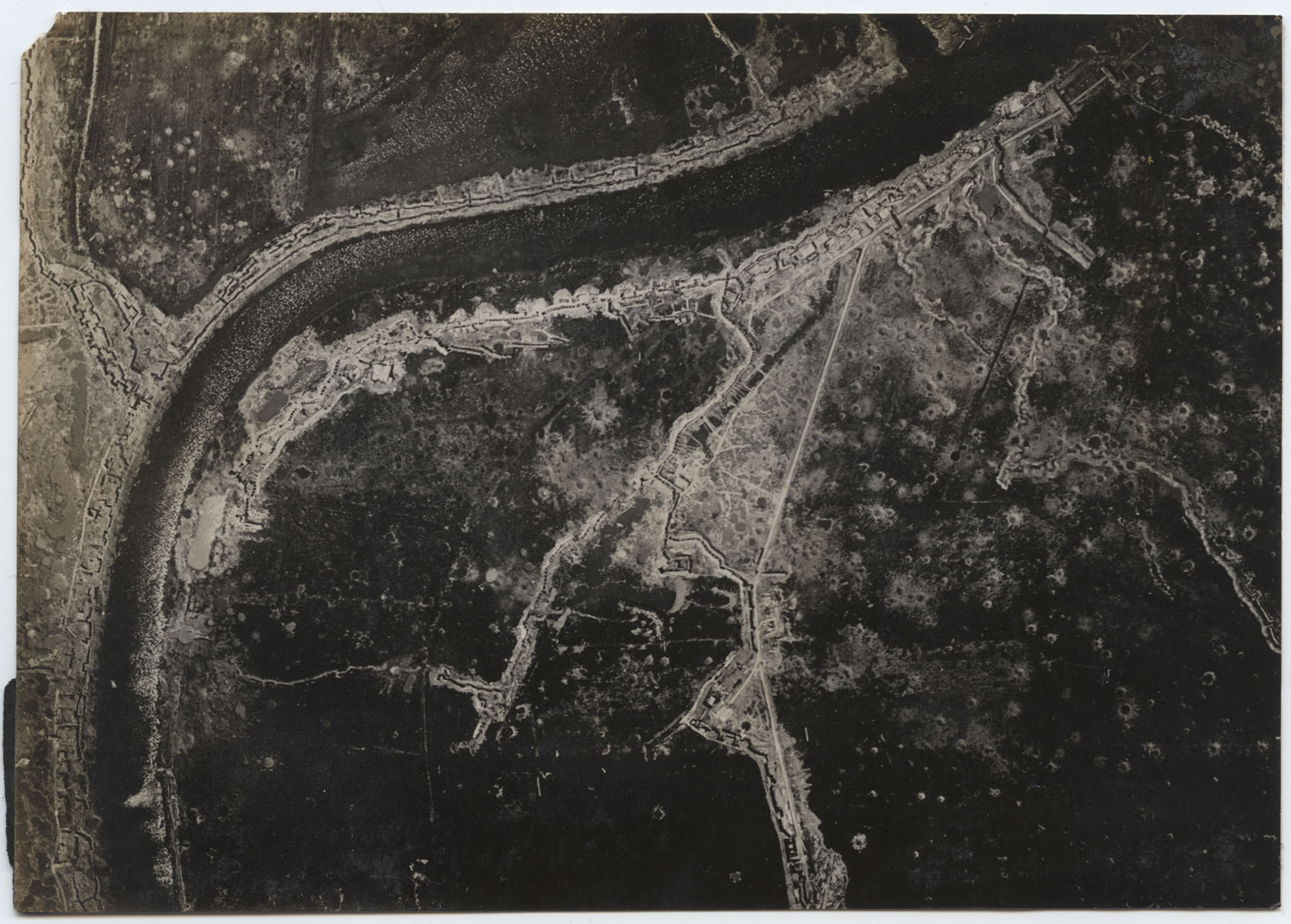 Black and white aerial photograph of trench lines snaking over a vast area with shell craters dotting the landscape