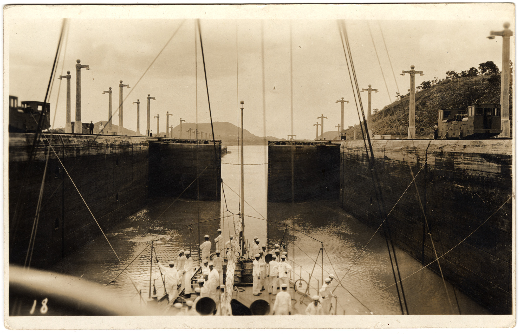 Black and white photograph of a ship in a canal lock that is filling with water