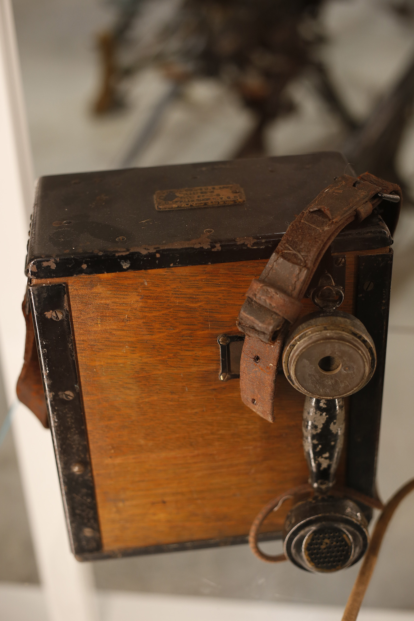 Worn-out wood box with an equally worn-out telephone handset hanging from it