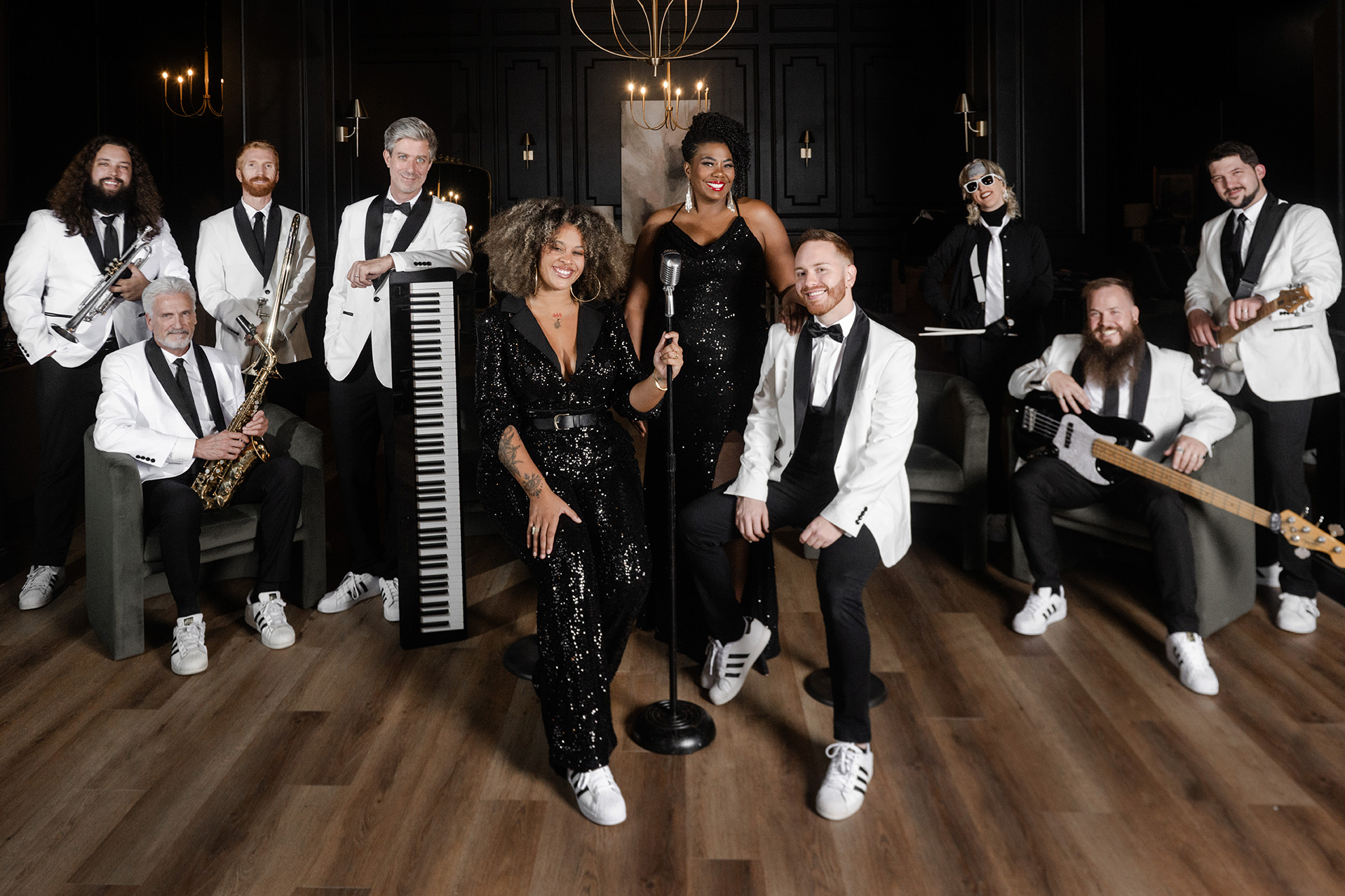 Large group portrait of musicians and vocalists dressed in snazzy black-tie attire