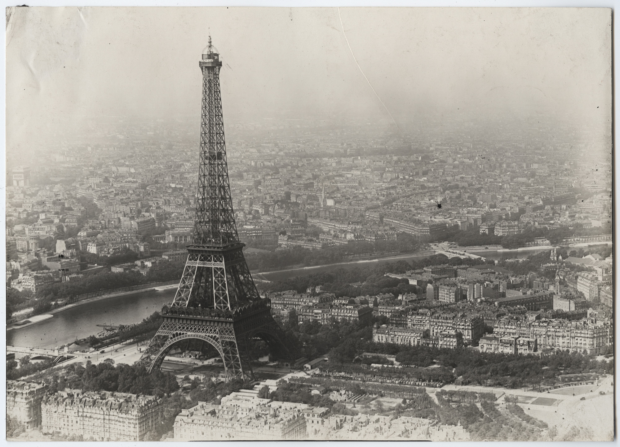 Black and white aerial photograph of the Eiffel Tower and Paris spreading out around it