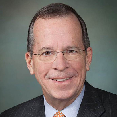 رجل أبيض مسن يرتدي نظارة وبدلة داكنة