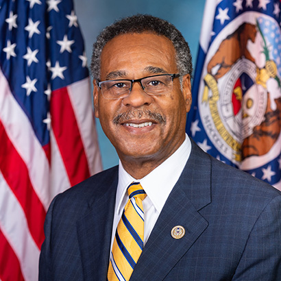 رجل أسود مسن ذو شعر وشارب رماديين يرتدي بدلة زرقاء داكنة