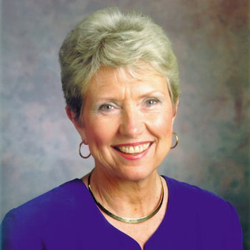 امرأة بيضاء مسنة ذات شعر أبيض قصير ترتدي قميصًا أزرق