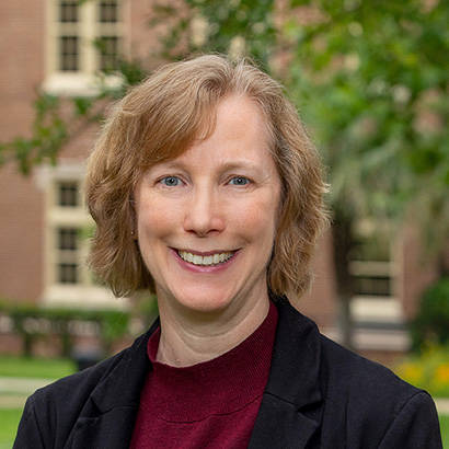 صورة حديثة لامرأة بيضاء ذات شعر بني فاتح ترتدي سترة داكنة