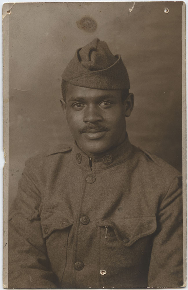Black and white portrait of a Black soldier with a neatly trimmed mustache, in military uniform