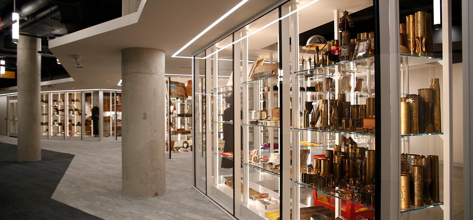 Modern photograph of glass shelving stretching away from the viewer, filled with WWI artifacts