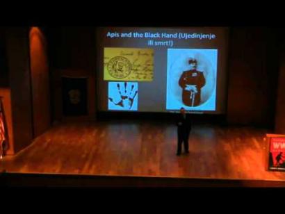 Photo of a man presenting a PowerPoint presentation on the auditorium stage.