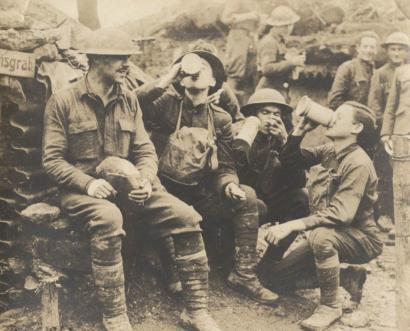 WWI soldiers drinking beer in a trench