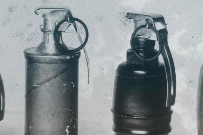 black and white photograph of different styles of grenades, lined up side by side