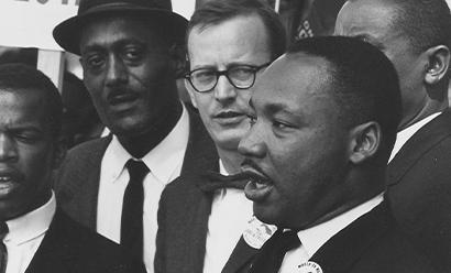 Black and white photo of Dr. Martin Luther King, Jr. speaking to someone out of frame.
