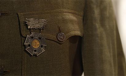 Close-up detail shot on an olive-colored uniform tunic and a medal hanging from the chest pocket