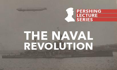 Photo en noir et blanc d'un cuirassé survolé par un zeppelin.